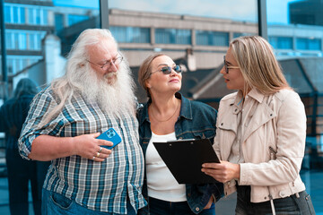 Group of friends engaging in a discussion outside a modern building on a sunny day, sharing...