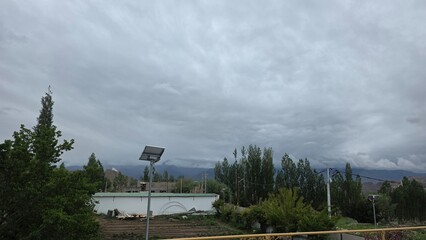 Solar panel near forest with cloudy Himalayan backdrop