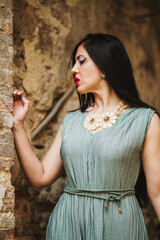 Obraz premium portrait of young woman with red lips and black dress in front of old house