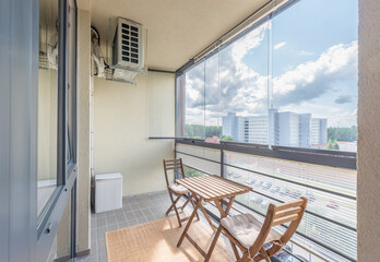 Cozy Urban Balcony with Wooden Furniture and Scenic City View