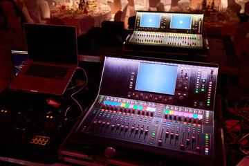 Closeup image of a hand mixing sounds on a control board, showcasing an audio technicians work