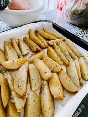 Delicious seasoned potato wedges prepared for baking in a home kitchen setting
