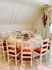 Elegant dining setting in a bright, cozy restaurant with a circular table and chairs