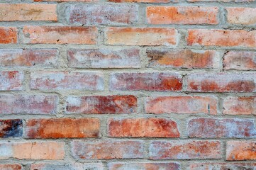 Detailed view of a red brick wall showing the texture of a weathered facade.