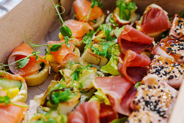 A box with an assortment of meat and fish appetizers for the buffet table.