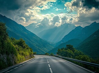 Beautiful, winding asphalt road in the green forest with mountains and clouds in the background, northern Italy. A scenic highway for car travel through the natural landscape of the Alps. Restaurant C