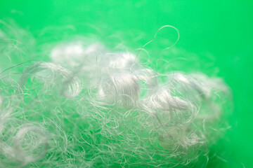Extreme macro of polyester stable fiber on green background. Selective focus, shallow depth of...