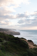 Wide sandy beach in the charming coastal town of Ericeira, Portugal. Clear blue sky and gentle ocean waves create the perfect summer atmosphere along the Atlantic coast.