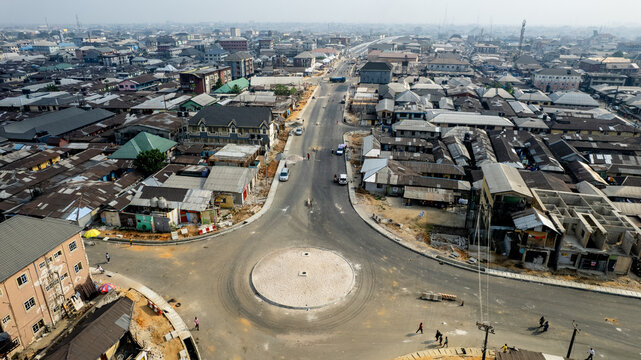 Aerial view of a roundabout where roads converge amidst a sprawling cityscape, a symphony of urban life unfolding from above, Benin City, Nigeria.