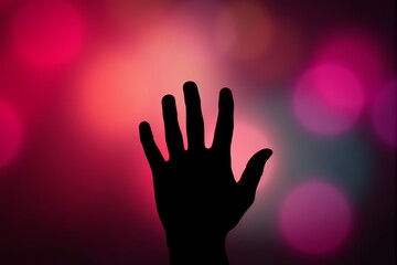 Silhouette of a hand reaching upward against a vibrant, blurred pink and purple bokeh background.  Perfect for concepts of hope, mystery, or reaching for dreams.