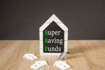 Concept words Super Saving Funds on black blackboard. Beautiful wooden table, black background. A...