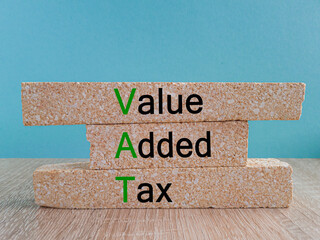 VAT - Value Added Tax symbol. Brick blocks with words Value Added Tax. Beautiful blue background,...
