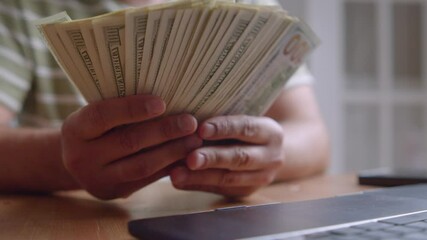 Young Freelancer Sitting At Desk Counting Cash After Online Project Completion, Laptop On Desk, Representing Remote Work Success, Salary Day, And Independence Through Digital Business - Powered by Adobe