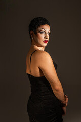 Bold Drag Queen Poses in Studio Portrait With Striking Expression and Elegant Black Attire