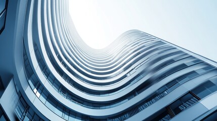 Low-angle view of a modern, curved skyscraper with numerous balconies and windows, extending towards a bright sky