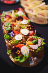 tartlets with pate and salad garnished with flowers. Delicious appetizers.
