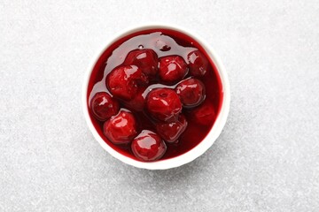 Tasty cherry jam on light table, top view