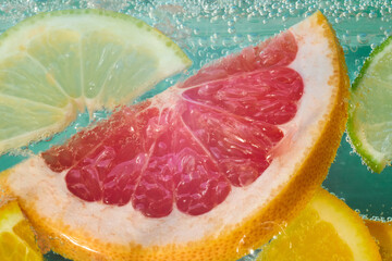 Bright slices of grapefruit, lime, lemon, and orange are immersed in sparkling water, creating a vibrant