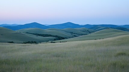 Rolling hills and grasslands under a pale sky.