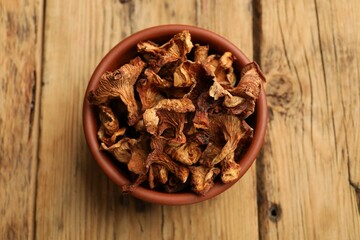 Dried chanterelle mushrooms on wooden table, top view