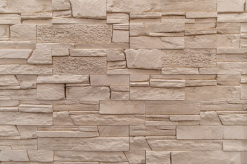 Textured beige stone wall with interlocking brick pattern