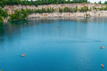 Scenic lake with canoes and lush green forests. Zakrzowek lagoon. Krakow