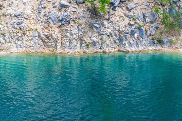 Clear blue lake with rocky shoreline and rippling water