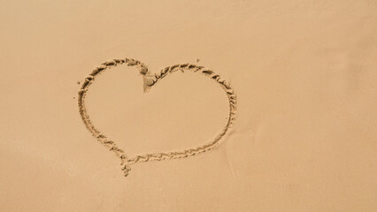Heart shape written on sandy beach
