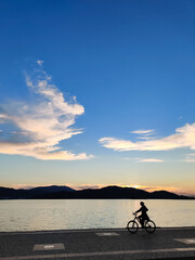 man riding a bicycle beautiful landscape of sunset on the sea beach