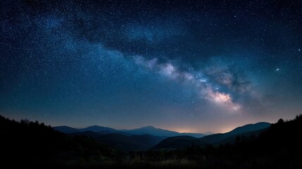 starry sky with visible arm of milky way galaxy over hills