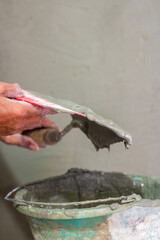 Hand holding cement mortar in tool