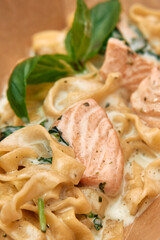 Creamy salmon pasta with basil and spinach in rich garlic sauce
