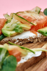 Delicious open-faced sandwich with fresh avocado, smoked salmon, and cream cheese on rustic whole grain bread