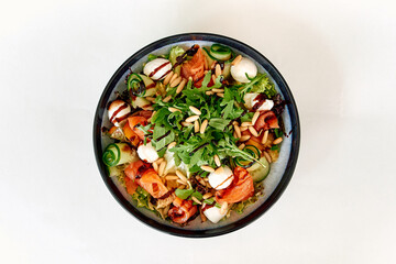 Vibrant salad with arugula, mozzarella, pine nuts, fresh vegetables, balsamic drizzle