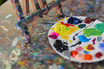 Art palette with colorful mixed paints  on smudges of paint wooden art table , concept art