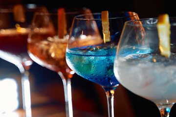 Vibrant cocktail display: blue and orange drinks in elegant glasses