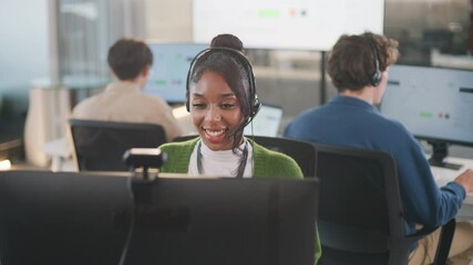Confident African American female call center agent communicates with clients using headset and computer. She offers professional tech support at a modern office desk, smiling diverse office - Powered by Adobe