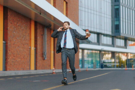 Rushing office man with coffee cups, tie flying, phone call in city