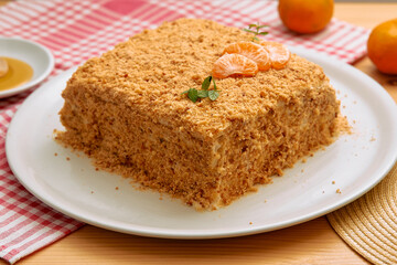 Square honey cake with crumb topping and tangerine slices on plate