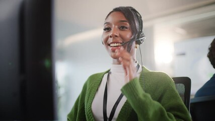 Smiling young african american professional customer support CRM Talking To Caller In Customer Services Department, Young Businesswoman Wearing Telephone Headset, Diverse call center team working - Powered by Adobe