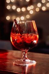 Luxurious crystal cocktail glass with icy red drink and illuminated bokeh in elegant ambiance