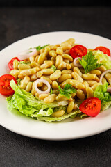 Bean salad green leaf lettuce, tomato, onion vegetables dish fresh delicious gourmet food background on the table rustic food top view copy space keto and paleo diet vegan and vegetarian food