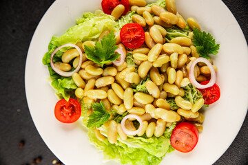 Bean salad green leaf lettuce, tomato, onion vegetables dish fresh delicious gourmet food background on the table rustic food top view copy space keto and paleo diet vegan and vegetarian food