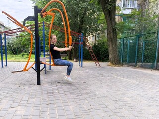 girl doing sports on the outdoor playground. young woman doing exercises