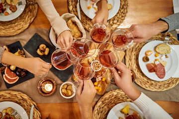 Celebration toast with friends over elegant dining setting featuring cheese and bread selections