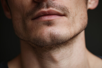 Obraz premium Close up of mans lower face lips and jawline skin with light stubble and natural texture showing subtle facial hair and smooth skin tone