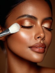 Bronzed Woman with Metallic Eye Makeup and Makeup Brush Highlighting Cheek in Glamorous Beauty Scene
