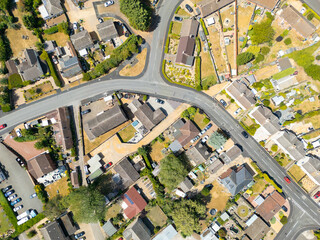 Drone top down view of a typical British town showing bungalows and houses adjacent to a road that snakes through the town. Seen during drought conditions in summer 2025.