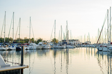 Obraz premium Large parking lot of white yachts in the bay of a French city at sunset. Summer seascape.