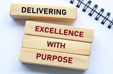 Delivering Excellence With Purpose text on wooden blocks. Quality delivery concept